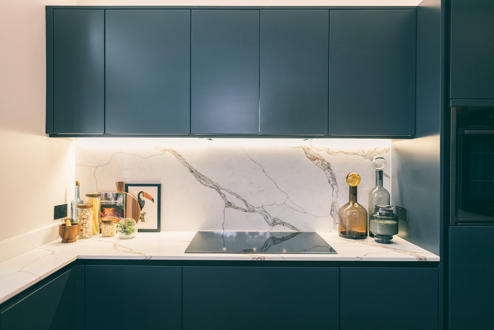 Navy kitchen run with induction hob, porcelain splashback and under-cabinet lighting