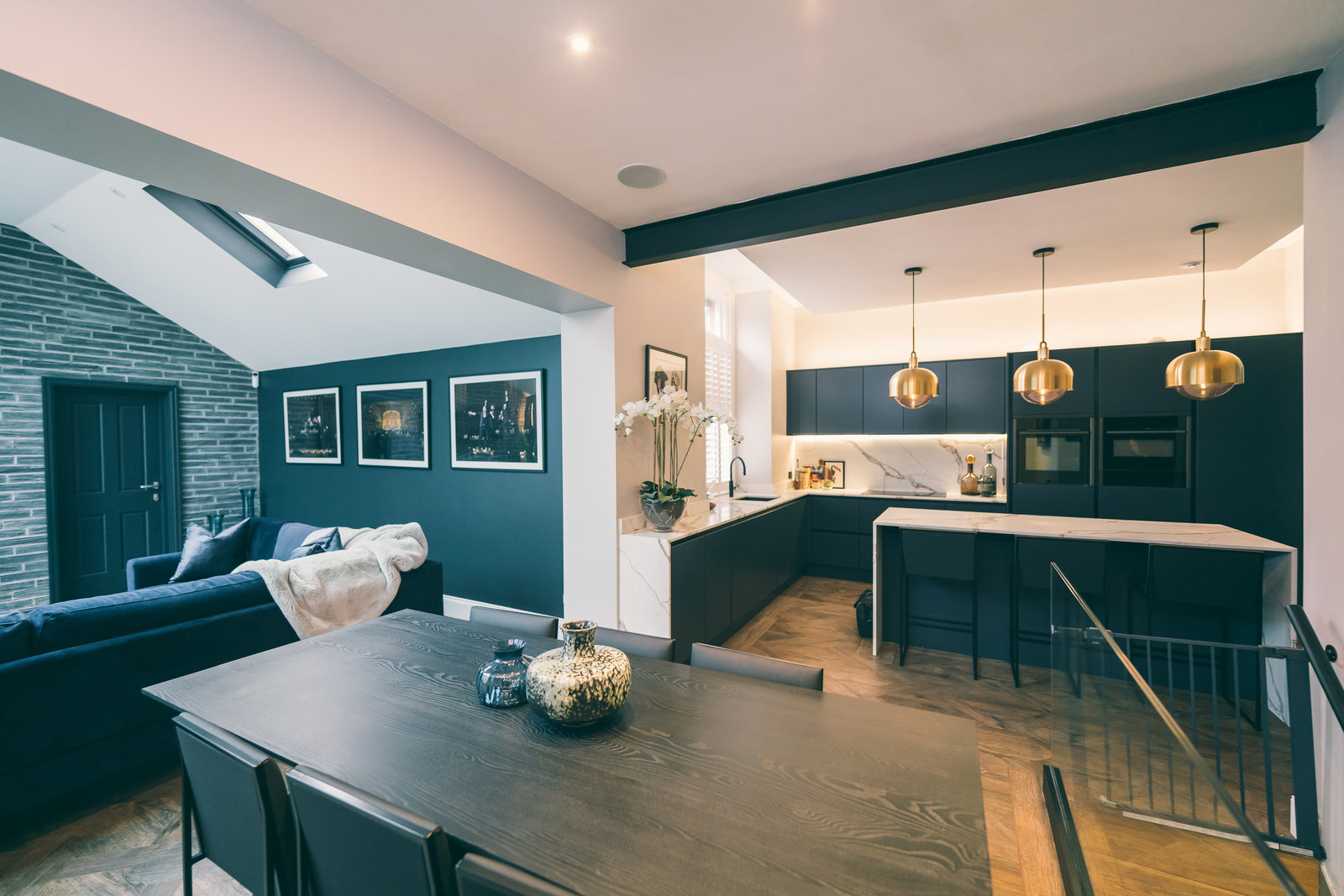 Glass-roofed navy kitchen extension with dining and living space in a Manchester home by Lisa Hensby Design & Build Studio
